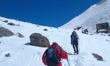 Trekkers walking through remote Buddhist villages of Tsum Valley with Mani walls, ancient monasteries, and snow-capped peaks in the background — hidden gem of the Manaslu region, Nepal.