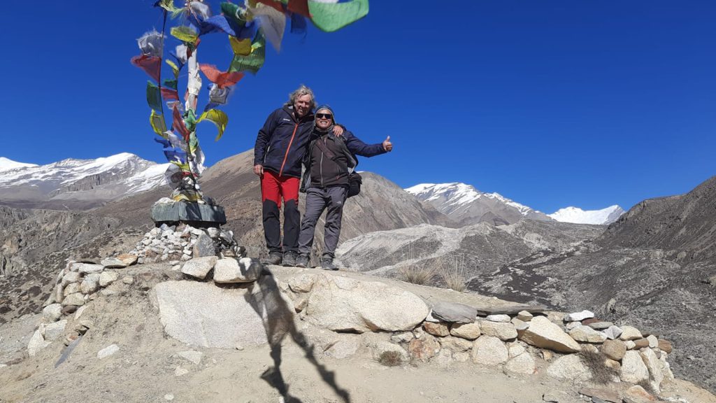 Trekkers exploring the remote Nar and Phu Valleys with traditional Tibetan-style villages and Himalayan peaks during the Nar Phu Valley Trek in Nepal.