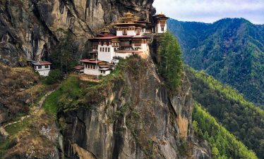 A breathtaking view of the iconic Tiger's Nest Monastery perched on a cliff in Bhutan's lush landscape.