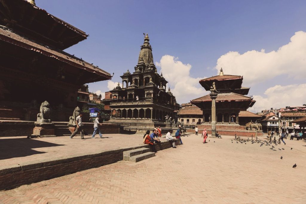 Vibrant scene at Patan Durbar Square, Nepal, showcasing ancient temples and tourists.