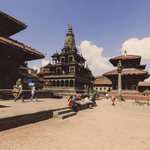 Vibrant scene at Patan Durbar Square, Nepal, showcasing ancient temples and tourists.