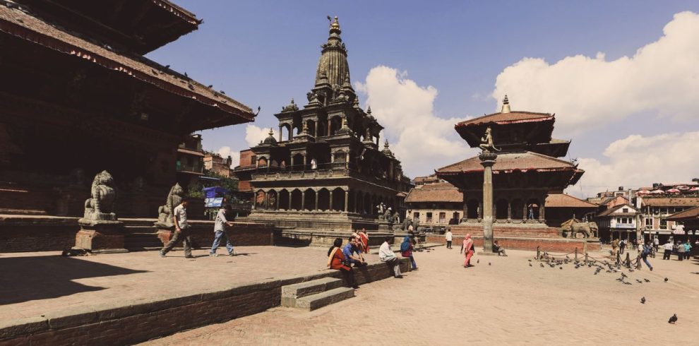 Vibrant scene at Patan Durbar Square, Nepal, showcasing ancient temples and tourists.