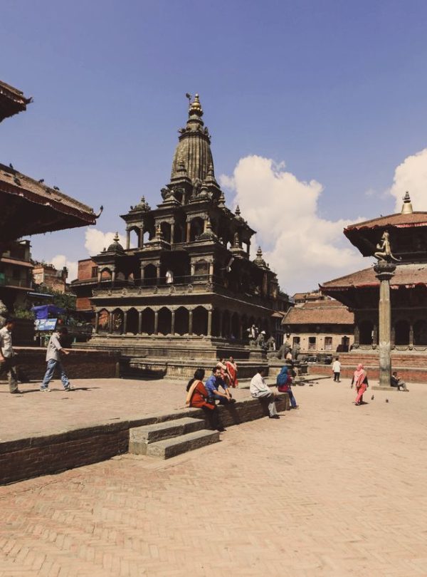 Vibrant scene at Patan Durbar Square, Nepal, showcasing ancient temples and tourists.