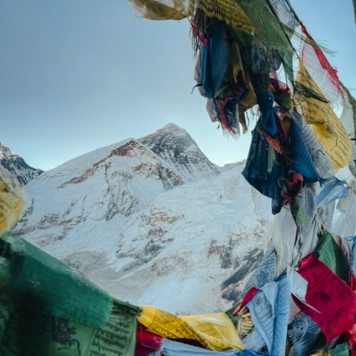 View of Mount Everest framed by colorful Tibetan prayer flags, capturing the peak's grandeur.