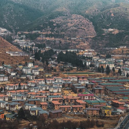 Aerial view of Thimphu city nestled in Bhutan's mountain landscapes, showcasing unique architecture and scenic beauty.