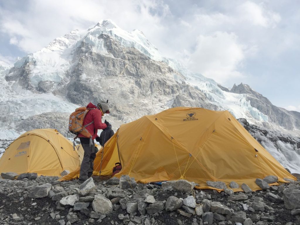 Yellow tents at Khumjung with majestic Himalayan peaks in the background, perfect for adventure travel