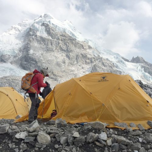 Yellow tents at Khumjung with majestic Himalayan peaks in the background, perfect for adventure travel