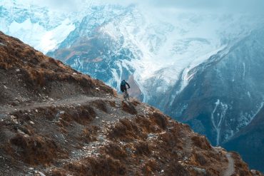 Mountain biker riding singletrack through pine forest above Kathmandu Valley, Nepal